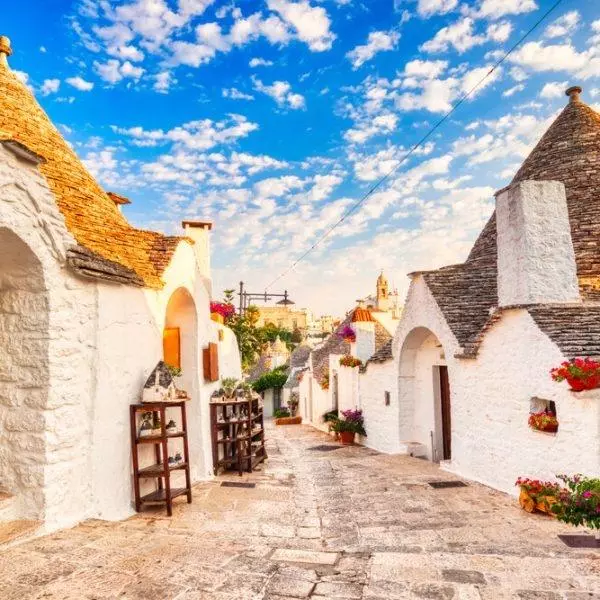 Famous Trulli Houses during a Sunny Day with Bright Blue Sky in Alberobello, Puglia, Italy       Keywords:                      trulli, alberobello, italy, puglia, bari, trullo, europe, landmark, monument, village, town, blue, sky, sunset, round, old, house, stone, white, wall, ancient, unesco, heritage, italian, history, rooftop, roof, building, architecture, picturesque, sunny, charming, famous, beautiful, art, attraction, district, traditional, unique, southern, mediterranean, vintage, typical, street, antique, home, historic, alley, monumental, location